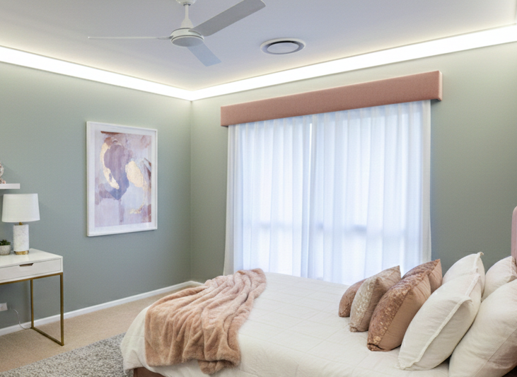 A modern residential bedroom featuring Illumicove crown molding providing high-intensity, direct white light along the ceiling perimeter.